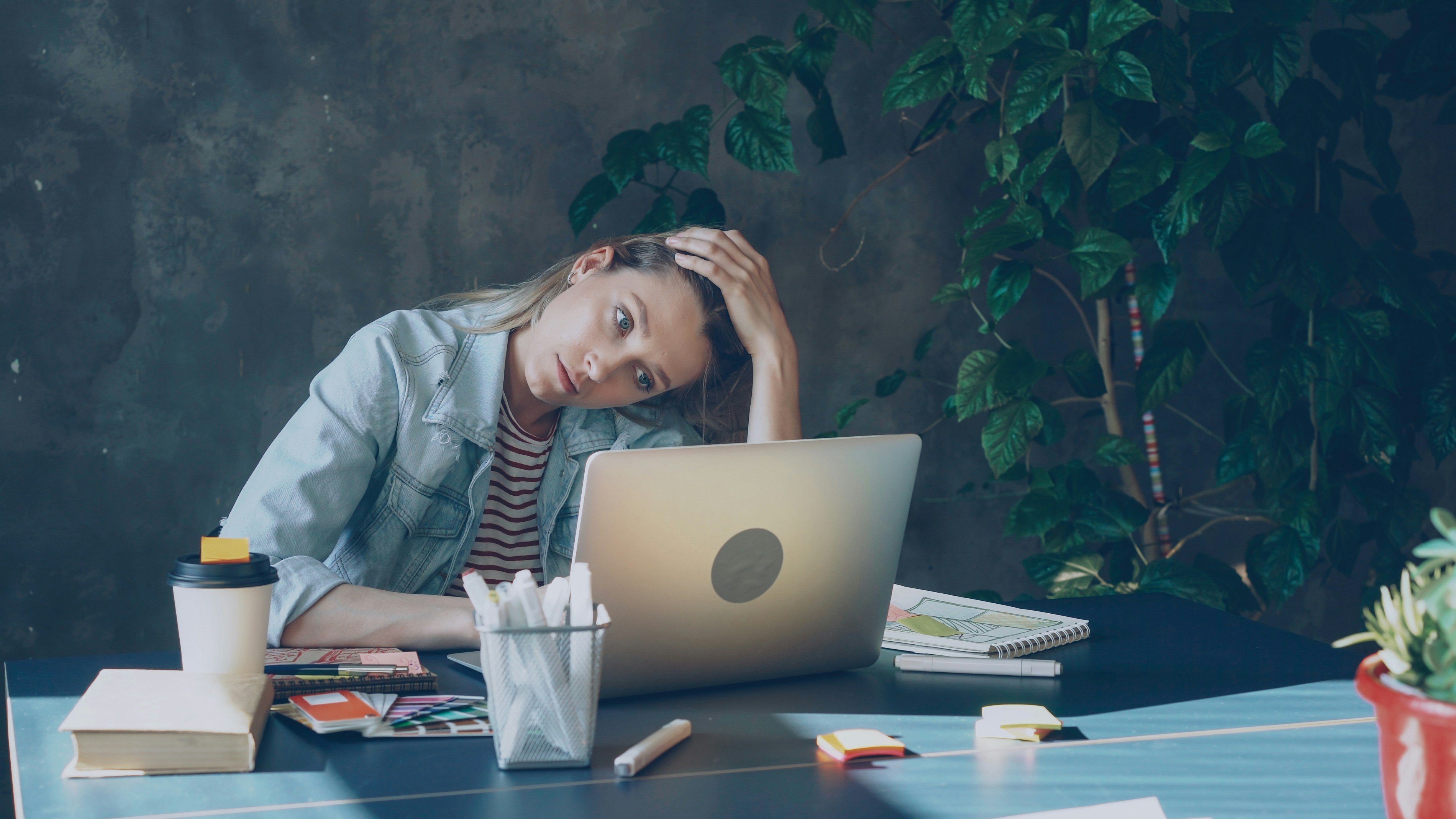 Women scratching head looking at laptop